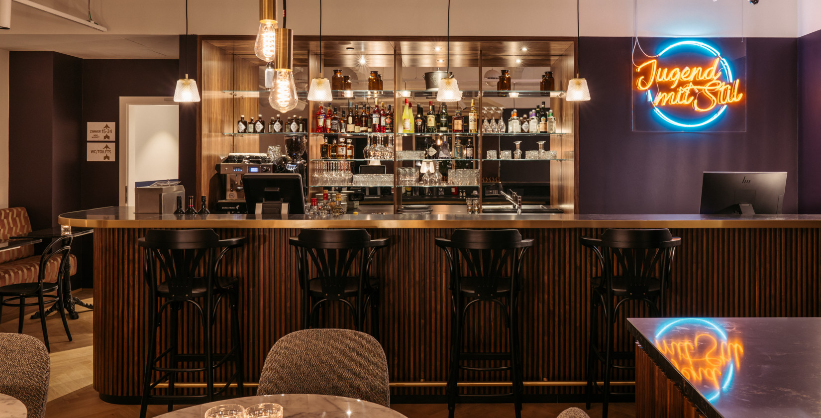 Stilvolle Bar mit Neonlicht und gemütlicher Atmosphäre im Hotel Schani UNO City