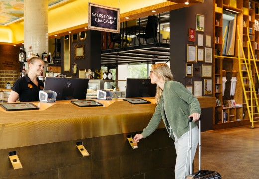 Frau beim Self Check-in in der Lobby