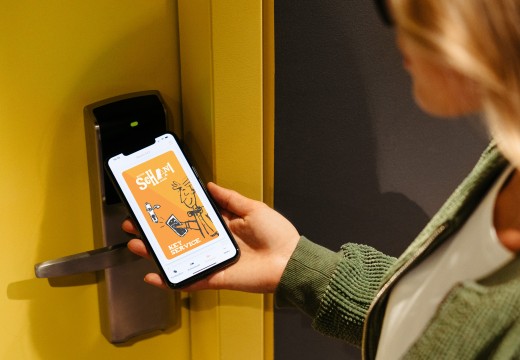 Frau öffnet mit Mobile Check-in und Mobile Key das Hotelzimmer