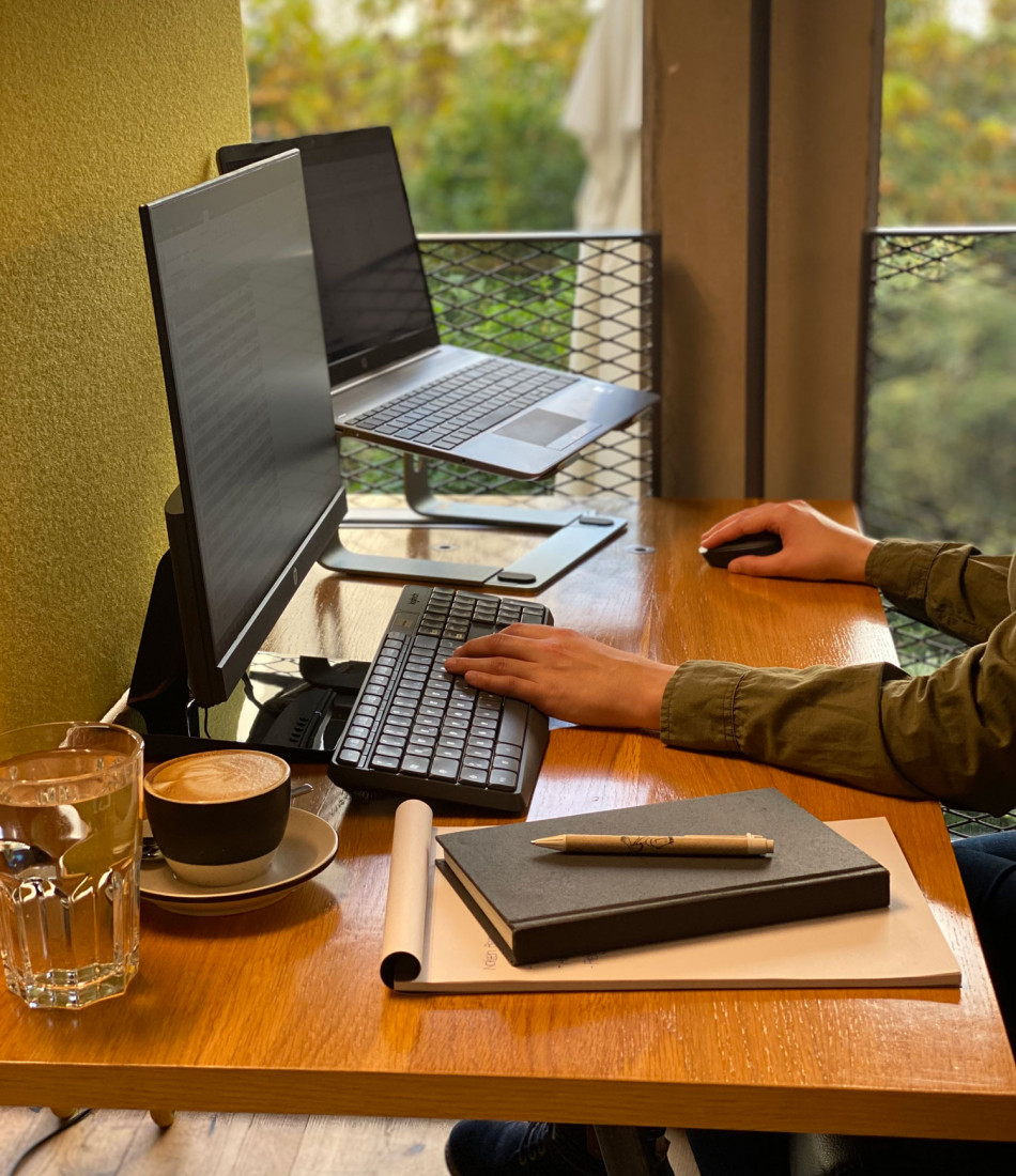 Nahaufnahme von einem Arbeitsplatz mit einem Laptop, Bildschirm und einer Tasse Kaffee im Hotel in Wien