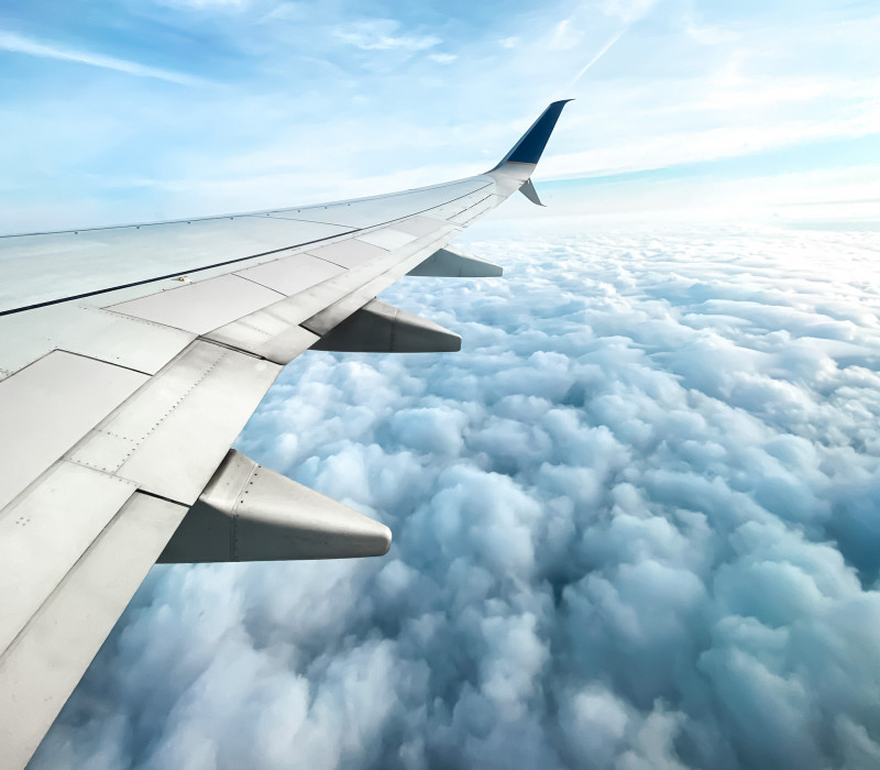 Blick aus dem Flugzeug zeigt die Wolken und den Flügel des Flugzeugs