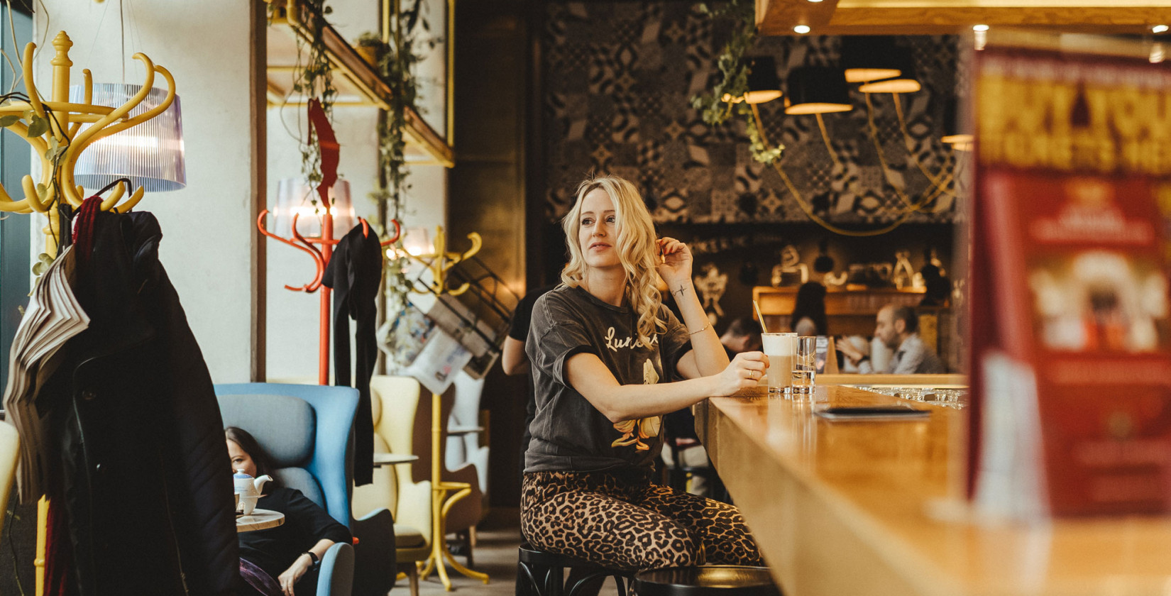 Frau sitzt an der Schani's Bar und trinkt Kaffee