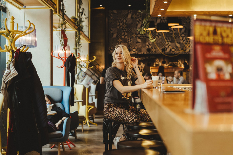 Laughing woman sitting with a coffee at Schani's bar