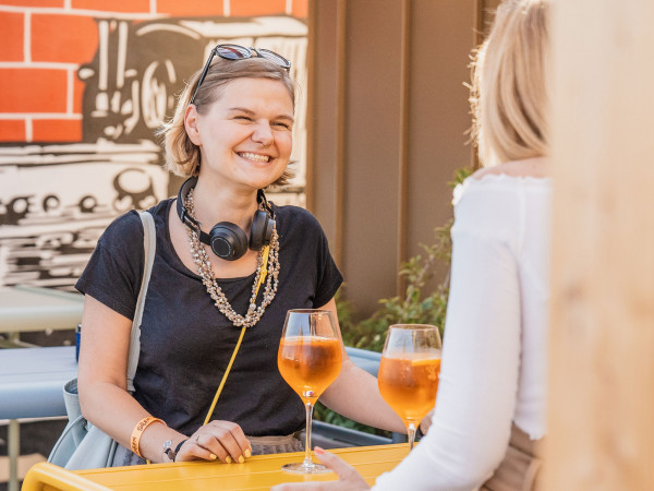 Frau lächelt und trinkt Cocktail bei einem Event in Schani's Rooftop