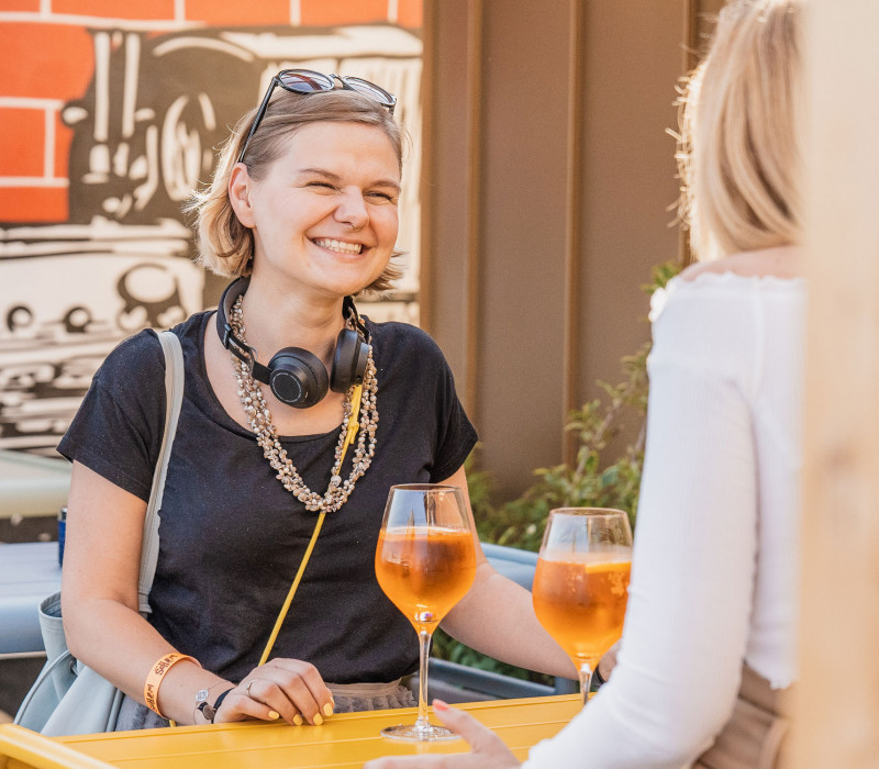 Two women with cocktails talk to each other in the event location in Vienna