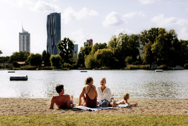 Familie, die im Gänsehäufel am Strand sitzt