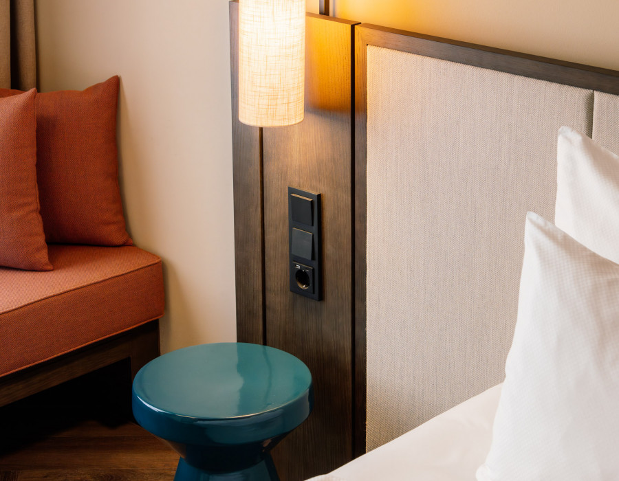 Power oulets next to a bed at Hotel Schani City
