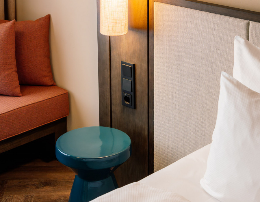 Power oulets next to a bed at Hotel Schani City