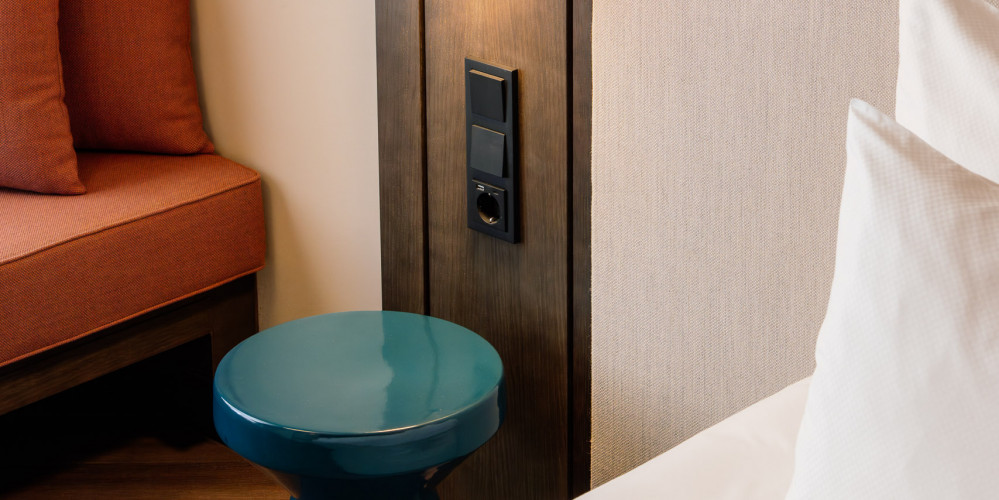 Steckdose neben dem Bett im Hotel Schani City 