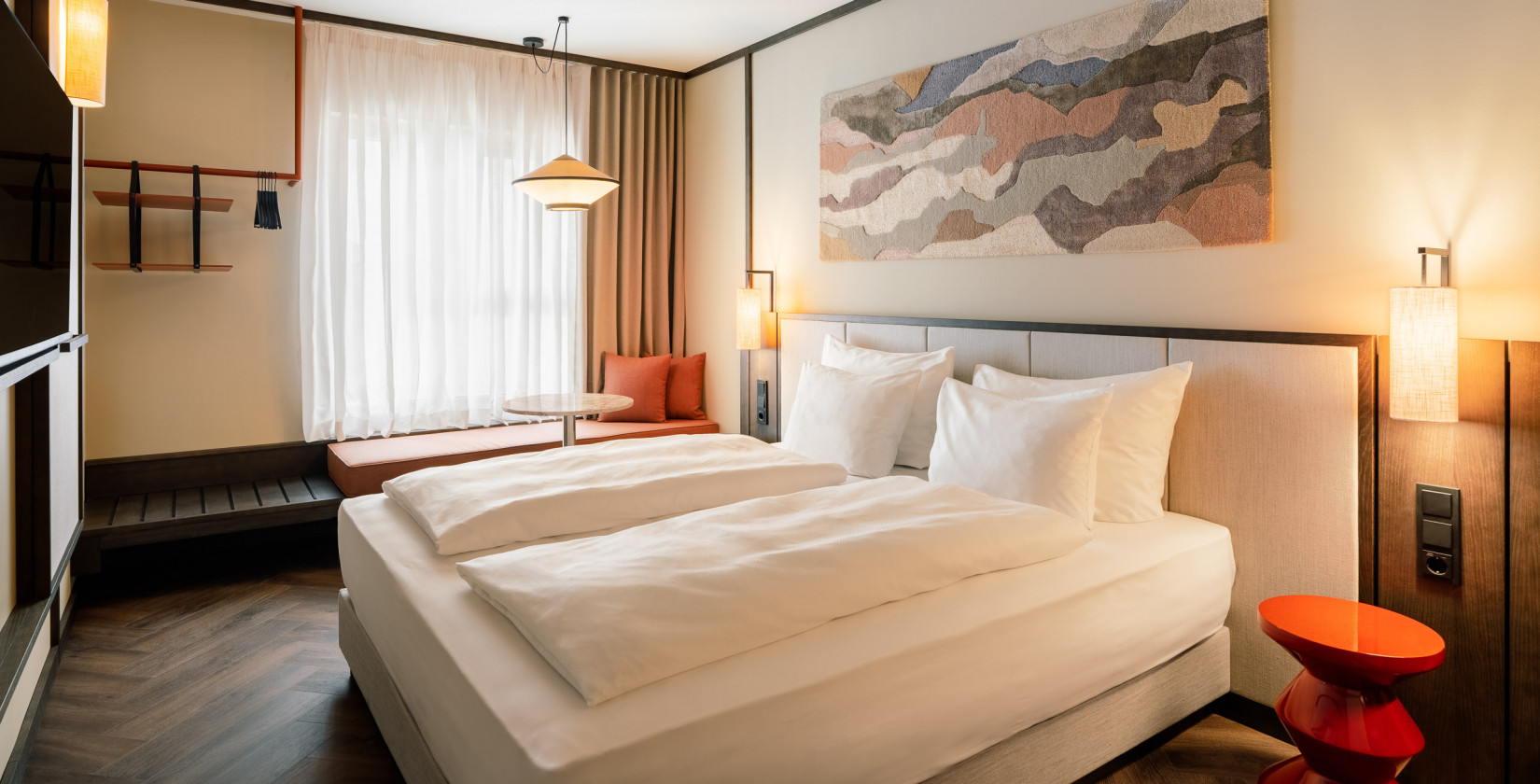 Doppelbett, Fensterbank und offener Kleiderschrank in einem Doppelzimmer im Hotel Schani City