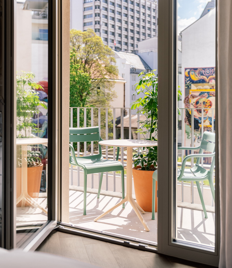View from the bed to the balcony in a room at Hotel Schani City 
