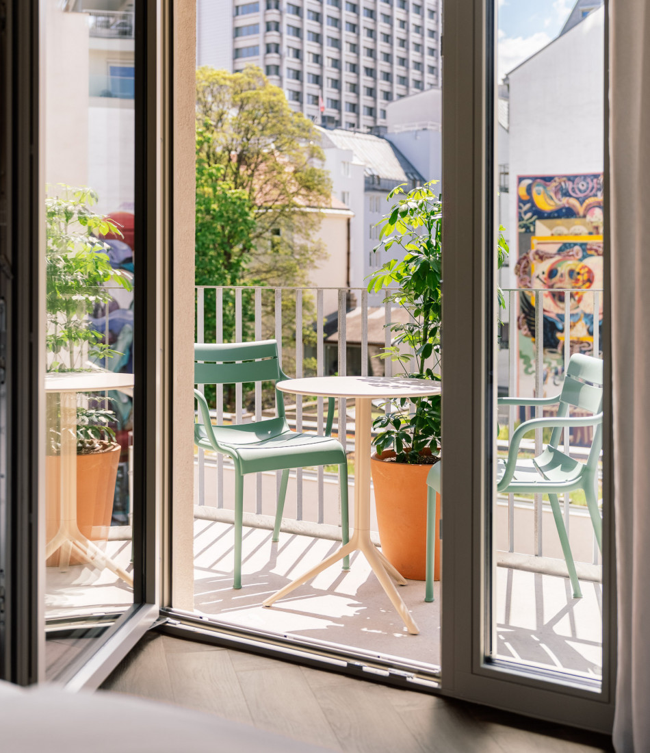 View from the bed to the balcony in a room at Hotel Schani City 