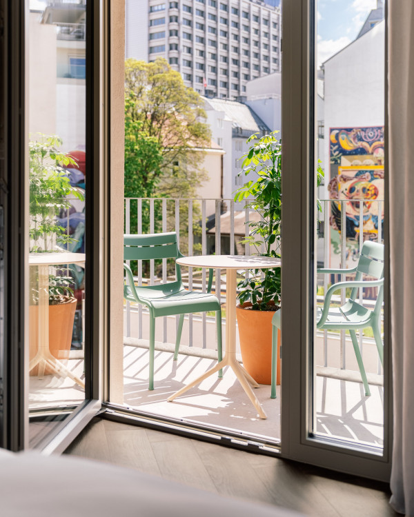 Blick vom Bett auf den Balkon in einem Zimmer im Hotel Schani City