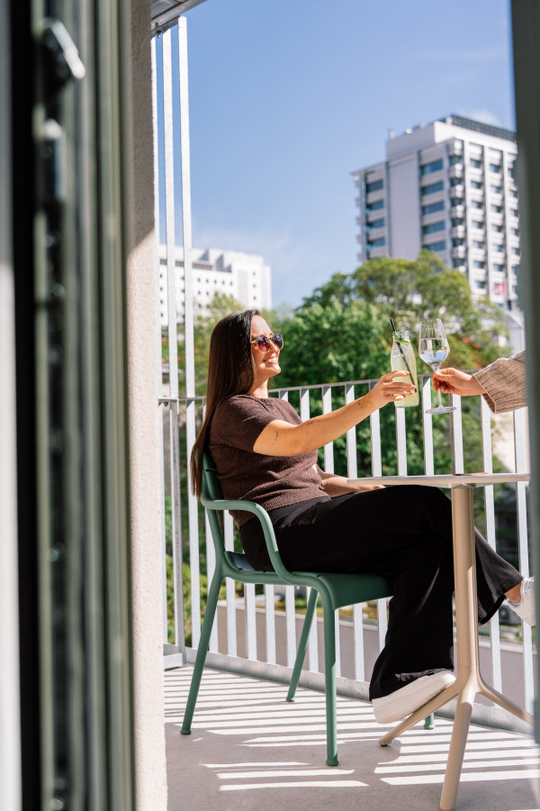 Lächelnde Frau auf einem Balkon im Hotel Schani City