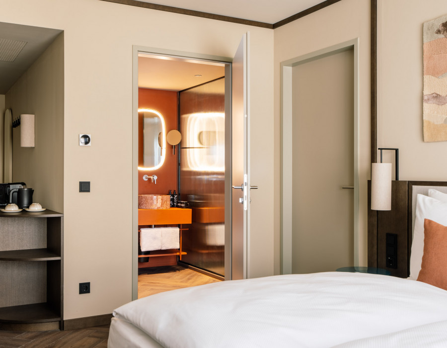 Double bed, coffee machine and connecting door in a family room at Hotel Schani City