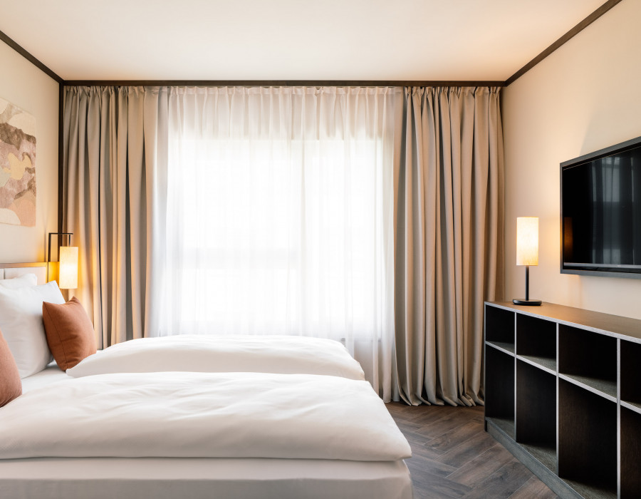 Double bed, TV and storage in a room at Hotel Schani City