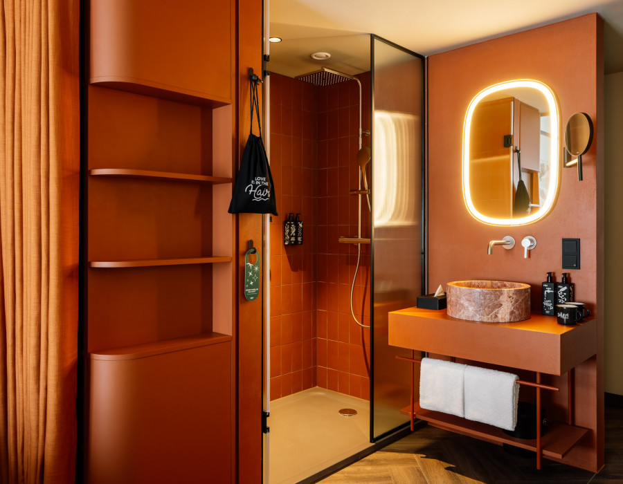 Bathroom with washbasin, rainshower, cosmetics and hairdryer in a hotel room 