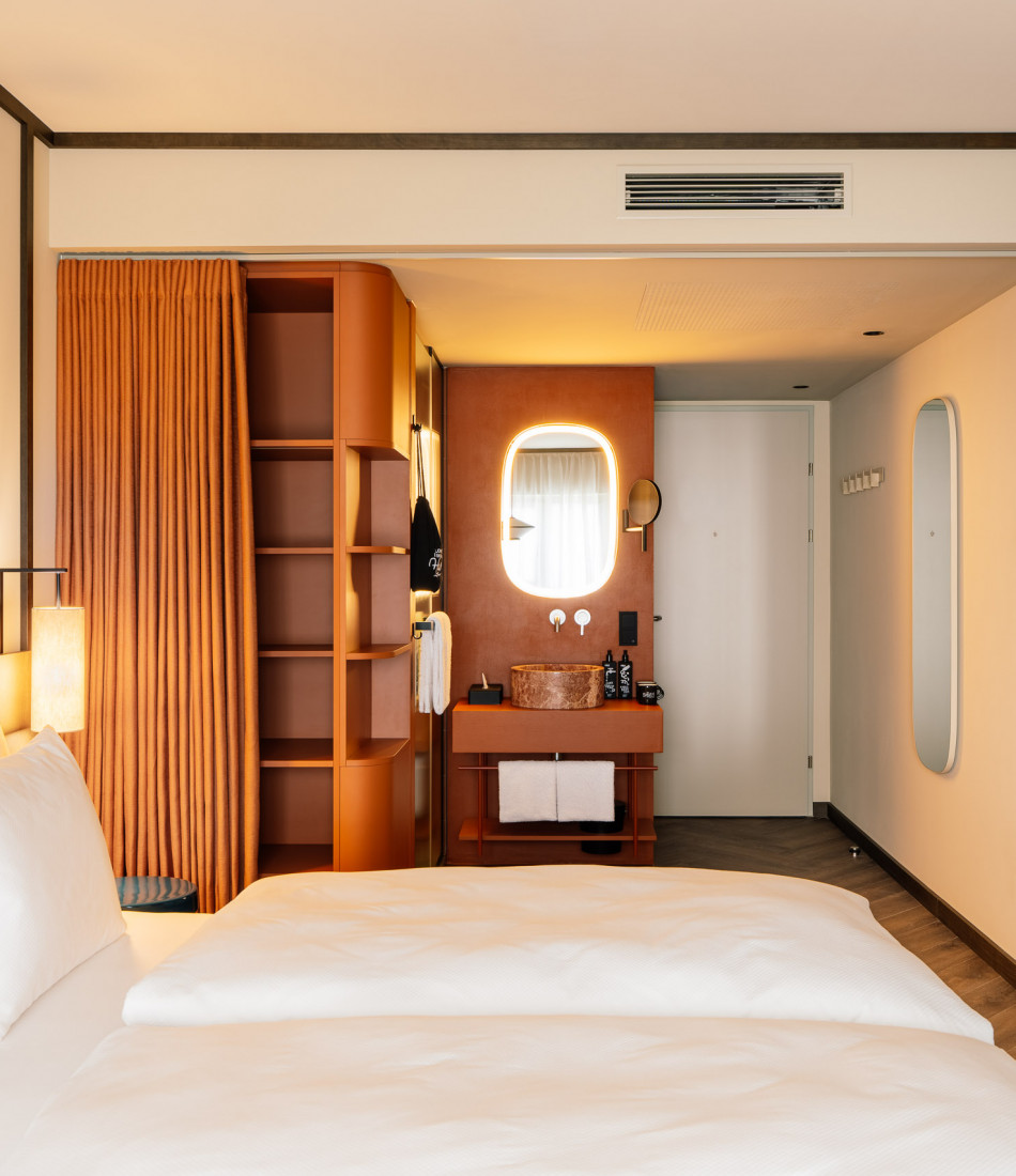 Hotelzimmer mit Doppelbett, offenem Bad und Ablageflächen