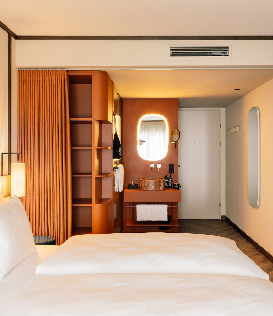 Hotel room with a double bed, open bathroom and wardrobe 