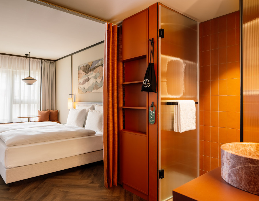 Hotel room with a double bed, open bathroom and wardrobe 