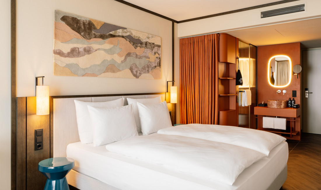 Double bed and open bathroom in a room at Hotel Schani City