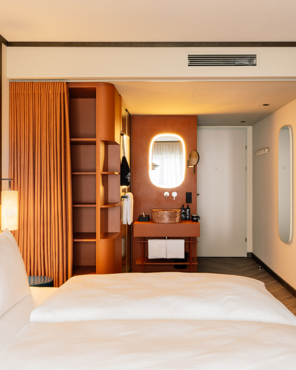 Hotelzimmer mit Doppelbett, offenem Bad und Ablageflächen