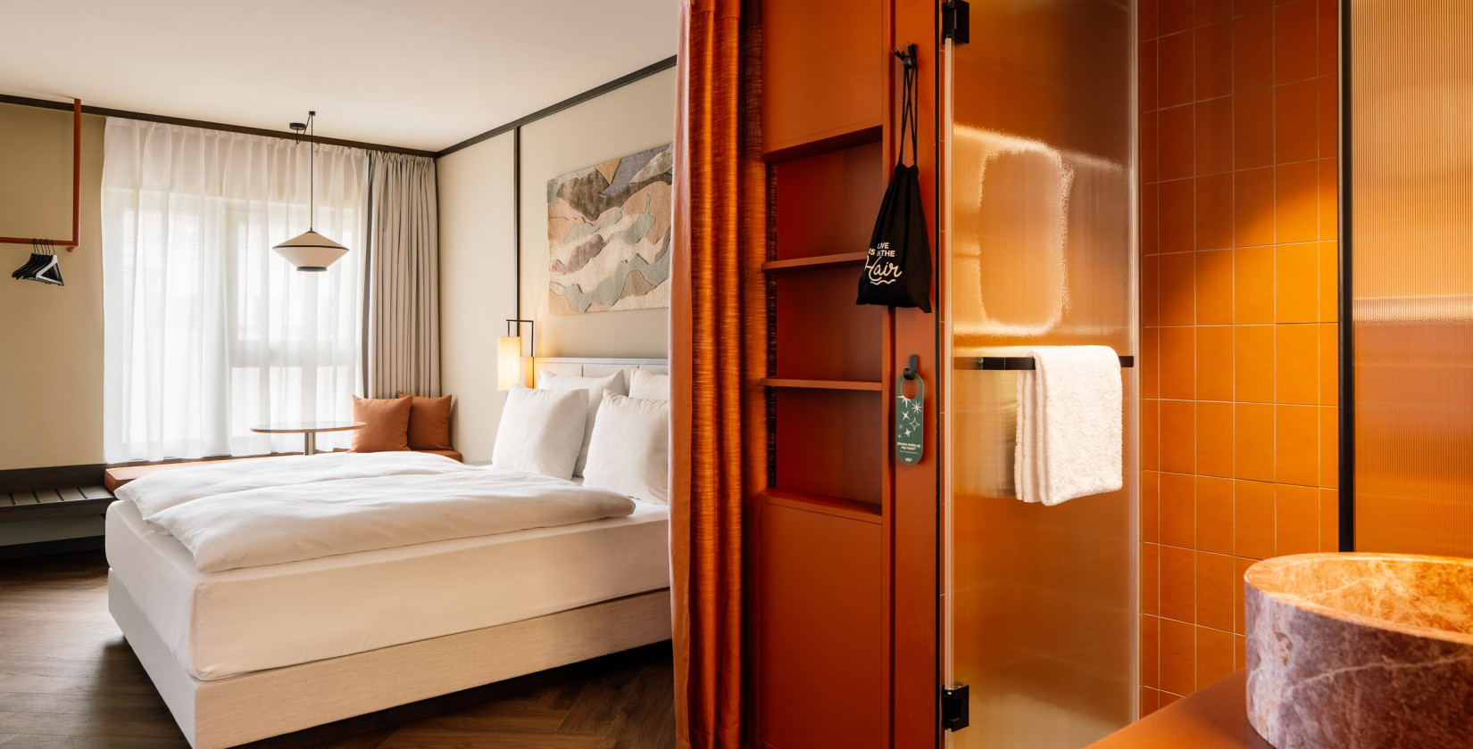 Double bed, window seat and cupboards in a room at Hotel Schani City