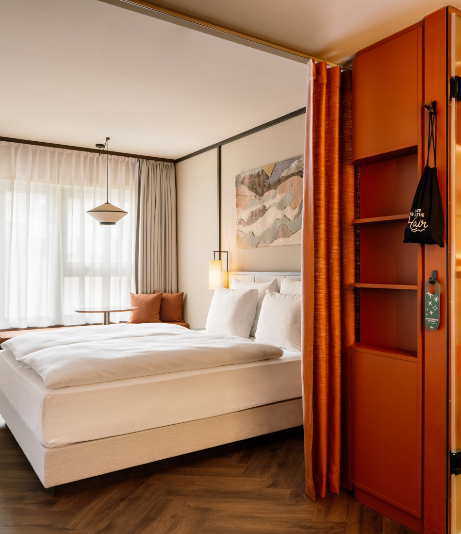 Doppelbett und Fensterbank in einem Zimmer im Hotel Schani City