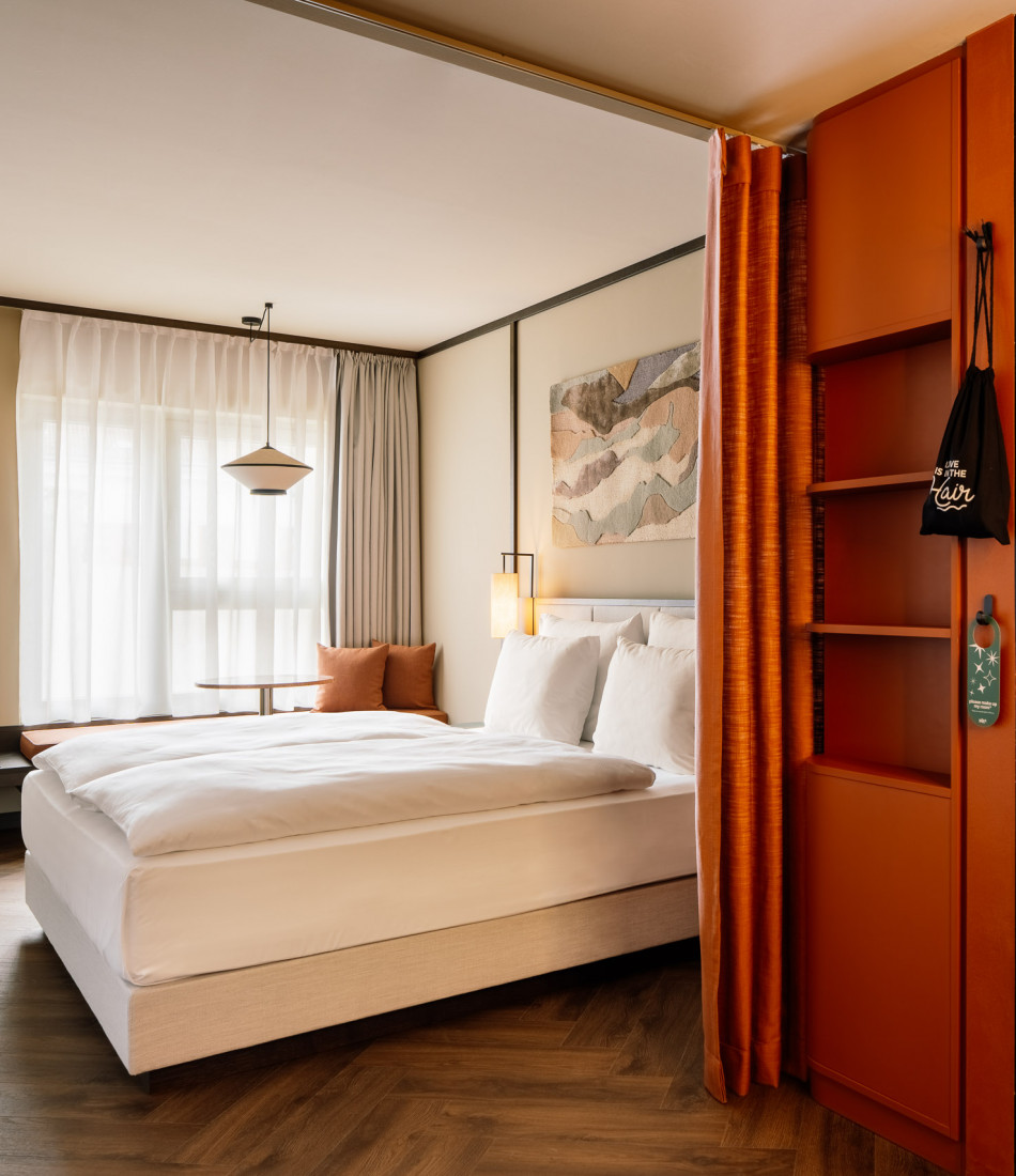 Double bed and window seat in a room at Hotel Schani City 