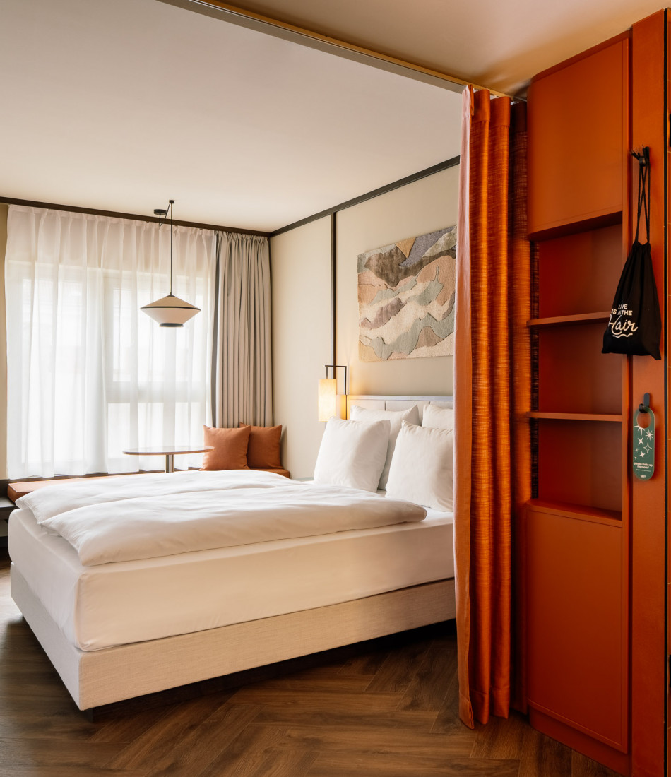 Double bed and window seat in a room at Hotel Schani City 
