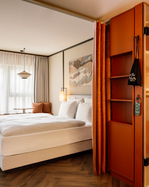 Doppelbett, Fensterbank und Ablageflächen in einem Zimmer im Hotel Schani City