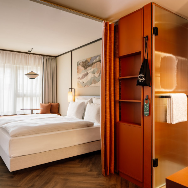 Doppelbett, Fensterbank und Ablageflächen in einem Zimmer im Hotel Schani City