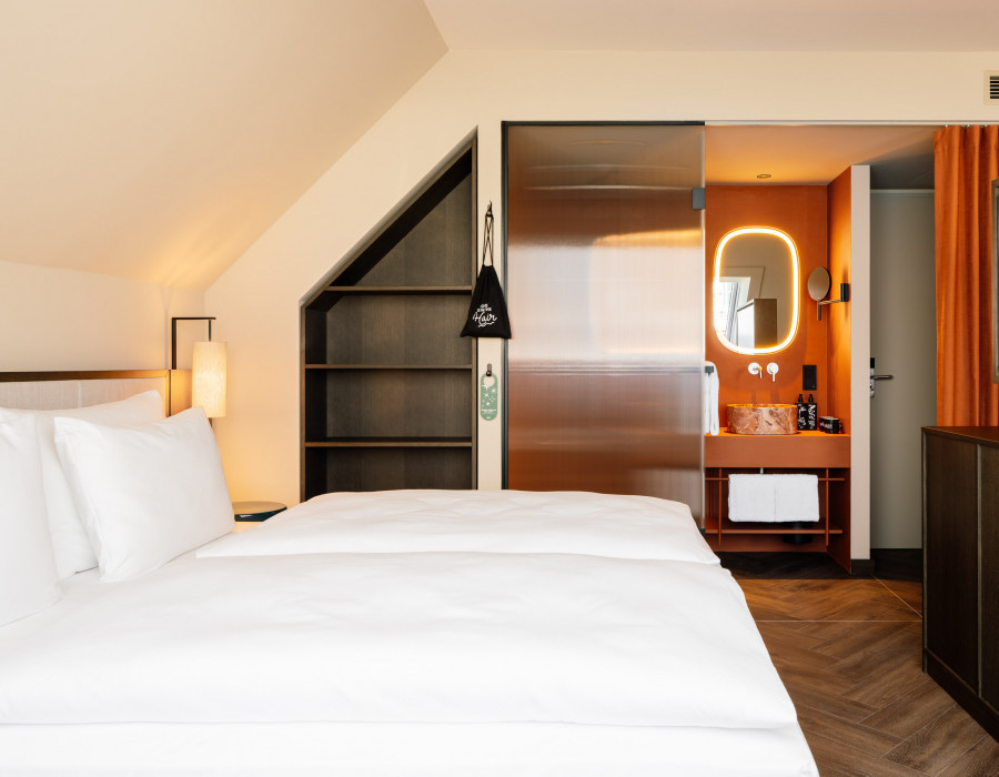 Double bed and bathroom in a hotel room for three guests