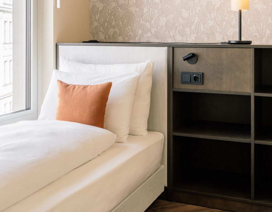Single bed and storage space in a hotel room