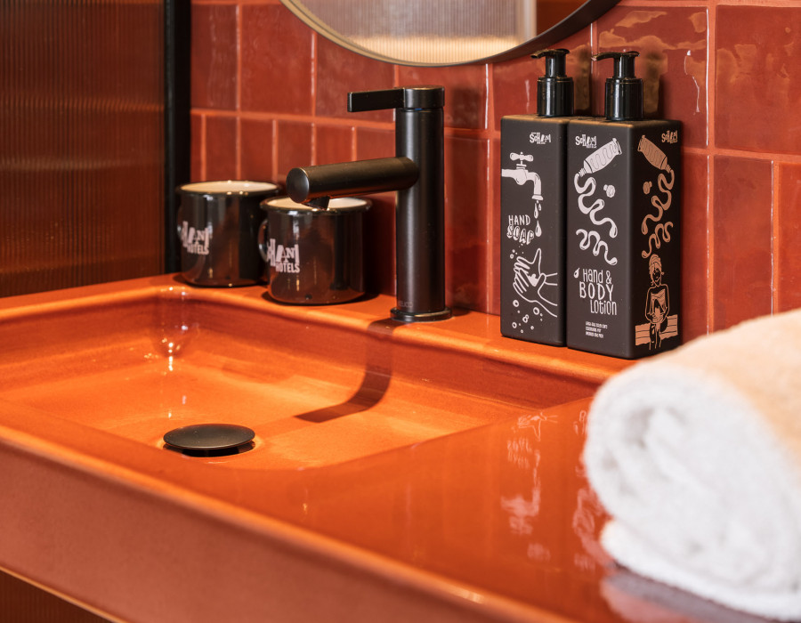 Nachfüllbare Kosmetik und Handtücher auf einem Waschtisch mit Waschbecken