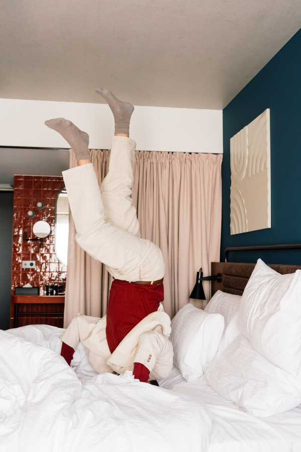 Ein Mann macht einen Kopfstand in einem Zimmer im Hotel Schani Naschmarkt