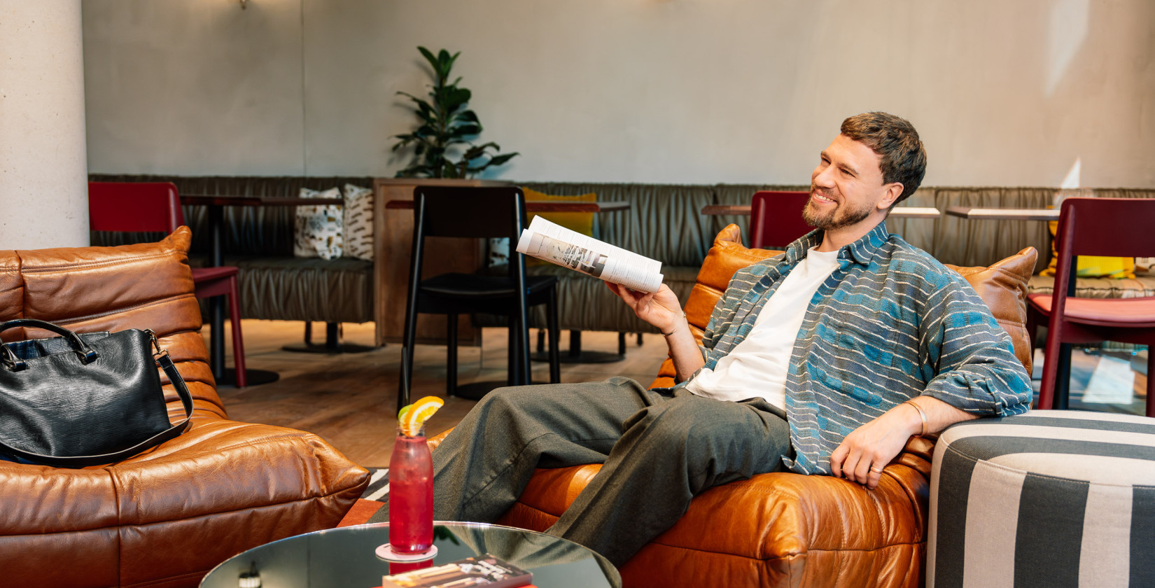Ein Gast mit einer Zeitschrift in der Lounge im Hotel Schani Naschmarkt
