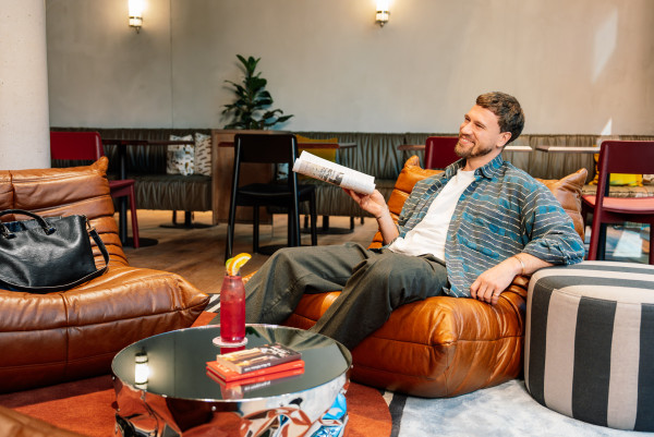 Ein Gast liest in der Lounge im Hotel Schani Naschmarkt eine Zeitschrift