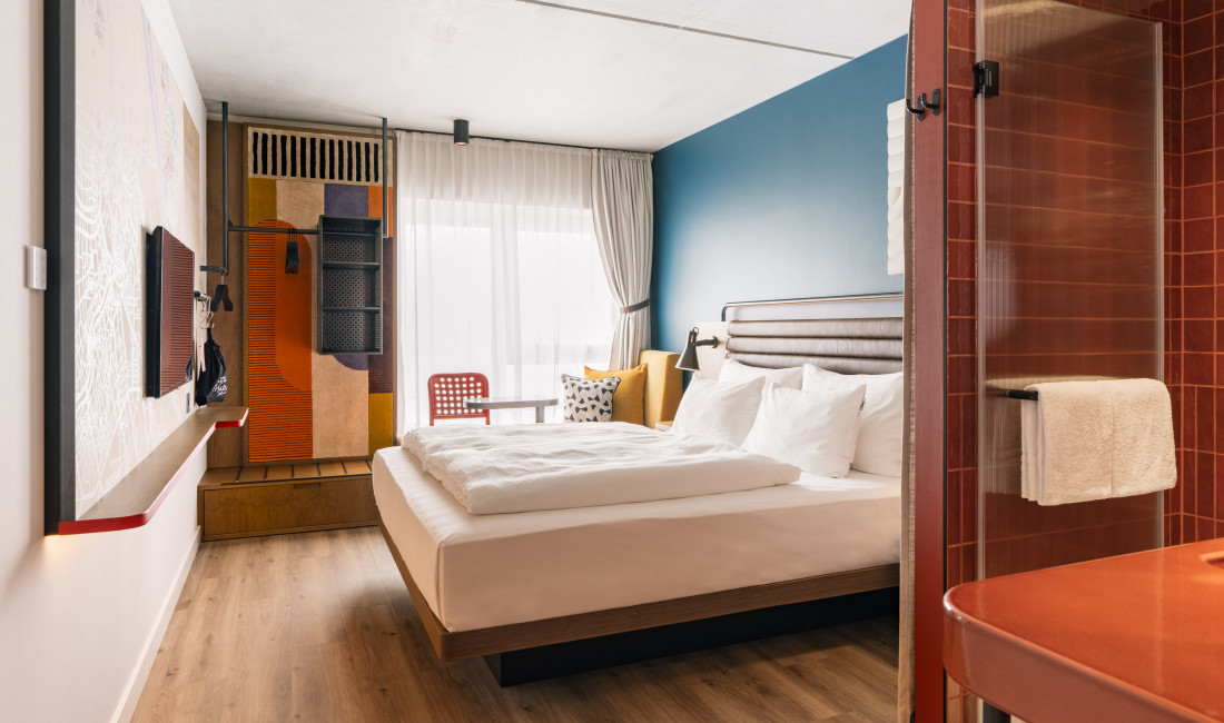Bed, window seat and open wardrobe in a room at Hotel Schani Naschmarkt