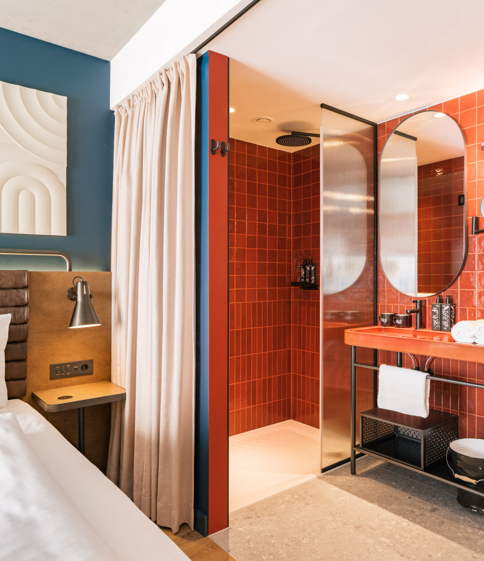 Offenes Badezimmer neben einem Doppelbett in einem Zimmer im Hotel Schani Naschmarkt