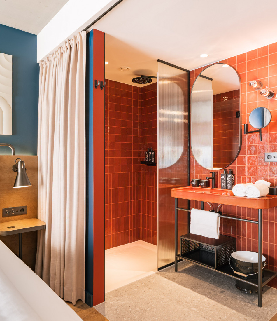 Offenes Badezimmer neben einem Doppelbett in einem Zimmer im Hotel Schani Naschmarkt