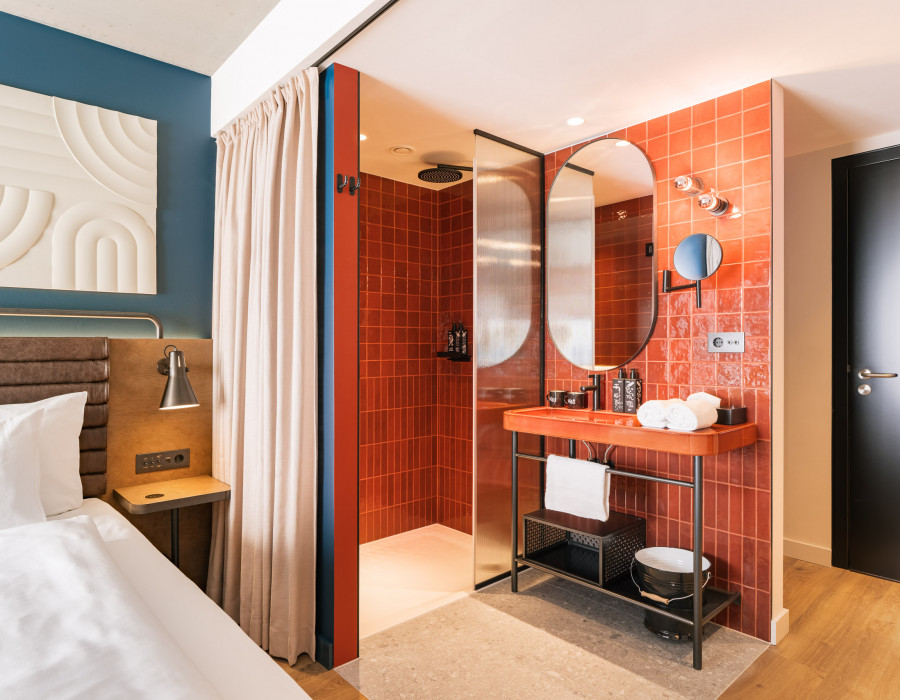 Doppelbett und offenes Badezimmer im Hotelzimmer beim Wiener Naschmarkt