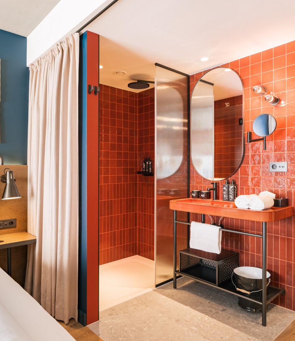 Offenes Badezimmer neben einem Doppelbett in einem Zimmer im Hotel Schani Naschmarkt