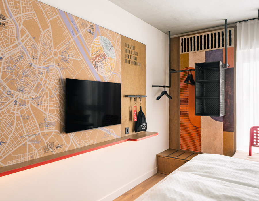 Fernseher und offener Kleiderschrank in einem Zimmer im Hotel Schani Naschmarkt