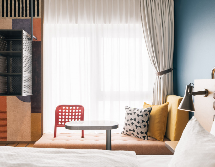 Gemütliche Sitzbank vor einem großen Fenster in einem Zimmer im Hotel Schani Naschmarkt