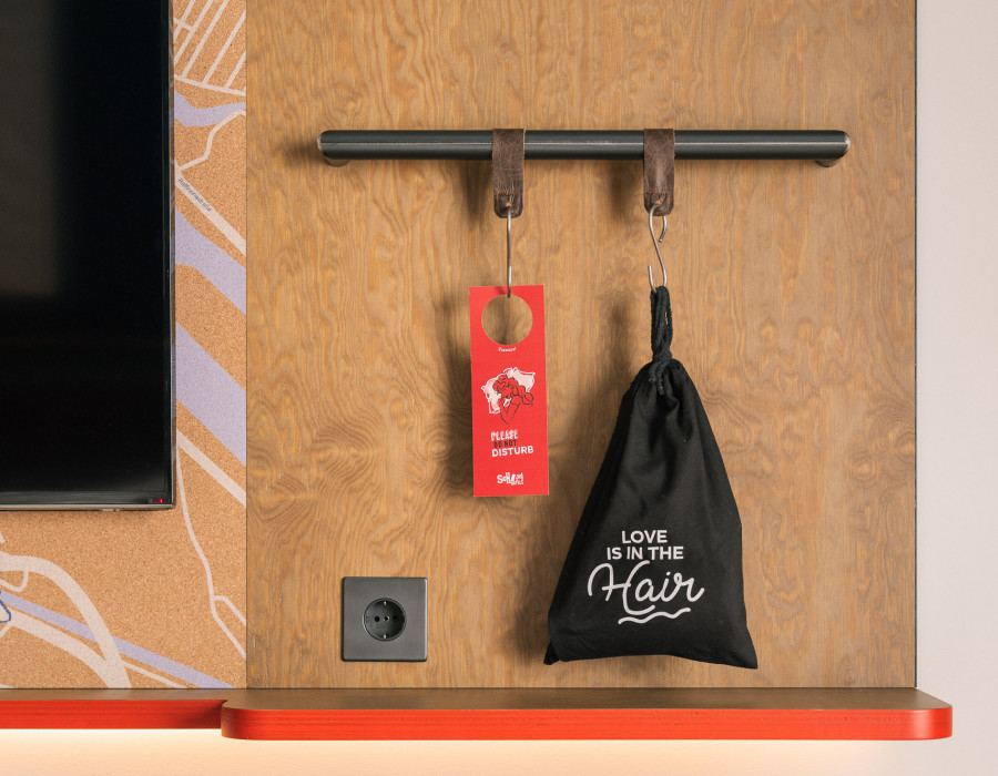 Wand mit Fernseher, Stadtplan von Wien und Steckdose in einem Hotelzimmer 