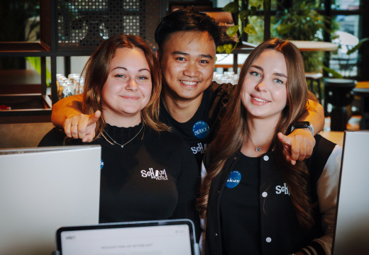 Drei Team-Mitglieder an der Rezeption lächeln