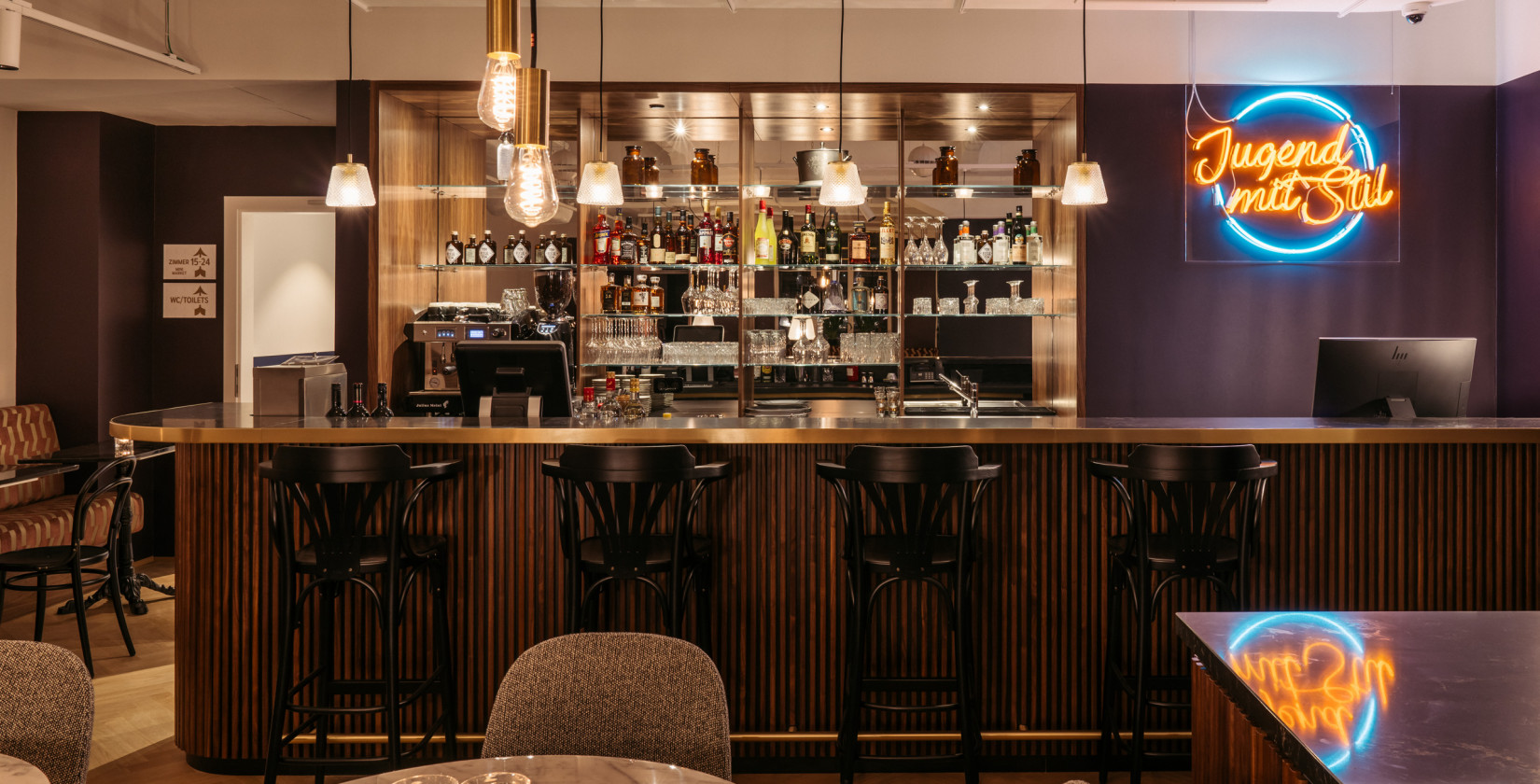 View of the reception with bar where four bar stools stand at the counter