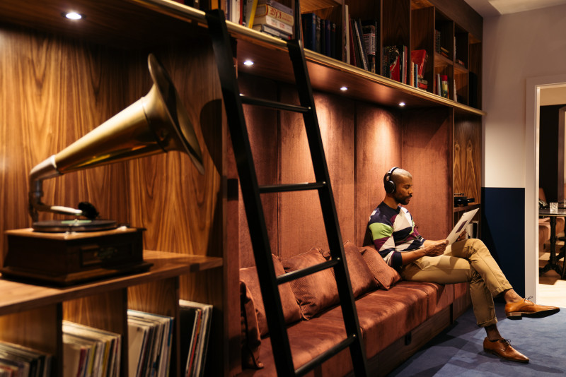 Man sitting in the library of the hotel Schani Salon