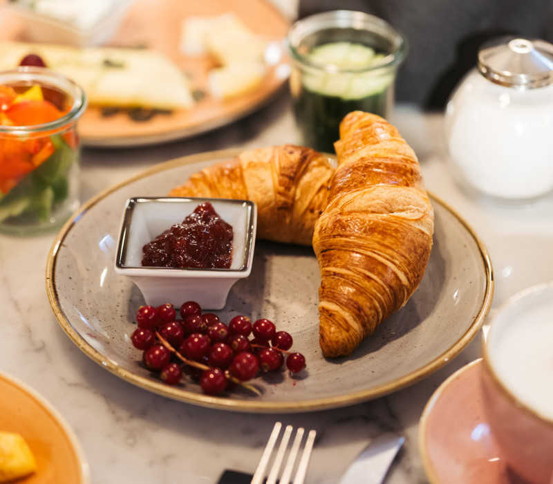 Croissants und Marmelade auf einem Frühstückstisch 